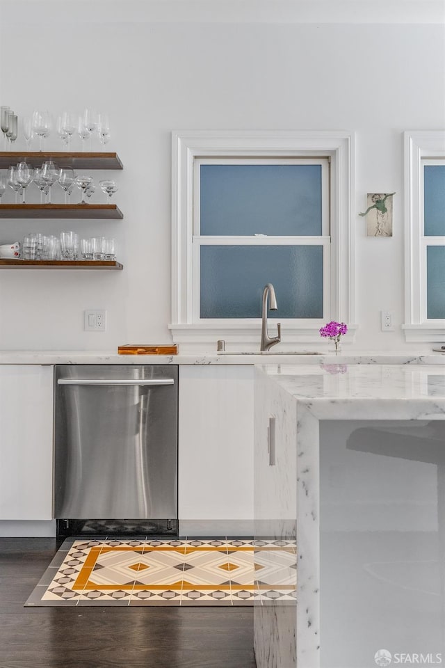 kitchen featuring light stone counters, sink, dark wood-type flooring, and stainless steel dishwasher