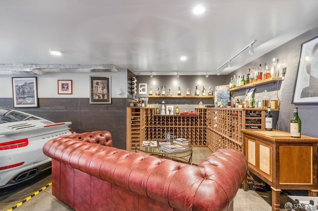 wine room featuring concrete flooring and track lighting