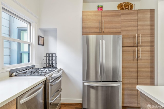 kitchen with appliances with stainless steel finishes and dark hardwood / wood-style flooring