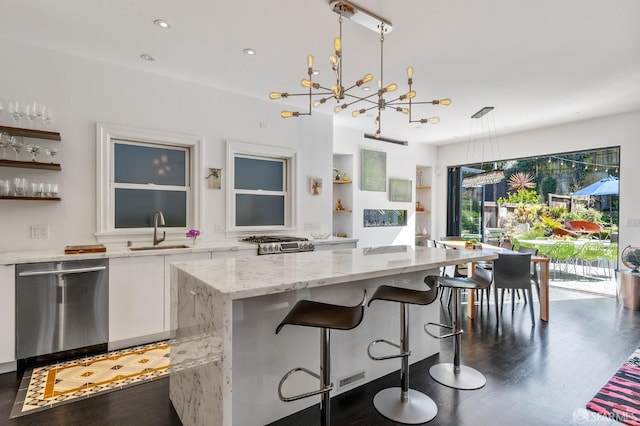 kitchen with pendant lighting, white cabinets, sink, dishwasher, and an inviting chandelier