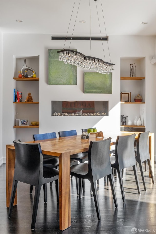 dining area featuring built in shelves and dark hardwood / wood-style flooring