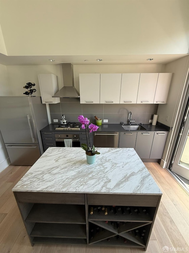 1075 Market St Unit 810, San Francisco, CA 94103 - kitchen featuring open shelves, wall chimney range hood, appliances with stainless steel finishes, a sink, and light wood-type flooring