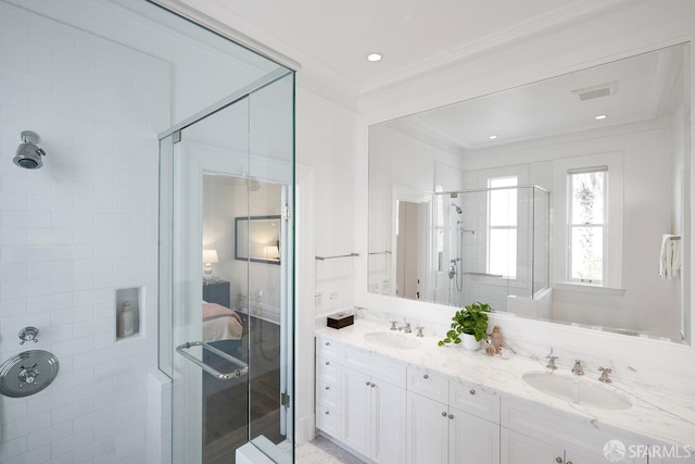 bathroom with a shower stall, ornamental molding, a sink, and double vanity