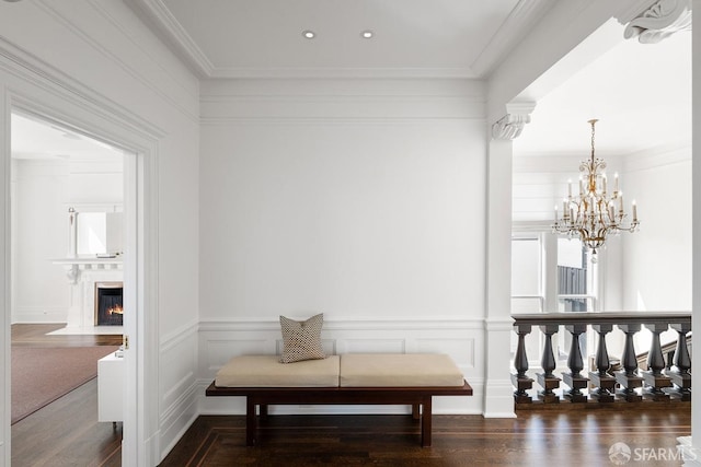 hallway featuring wood finished floors, a notable chandelier, and ornamental molding