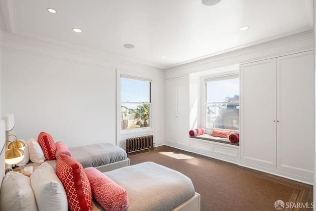 bedroom featuring dark colored carpet, recessed lighting, radiator heating unit, crown molding, and multiple closets