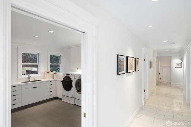 washroom with washing machine and clothes dryer, a sink, laundry area, and recessed lighting