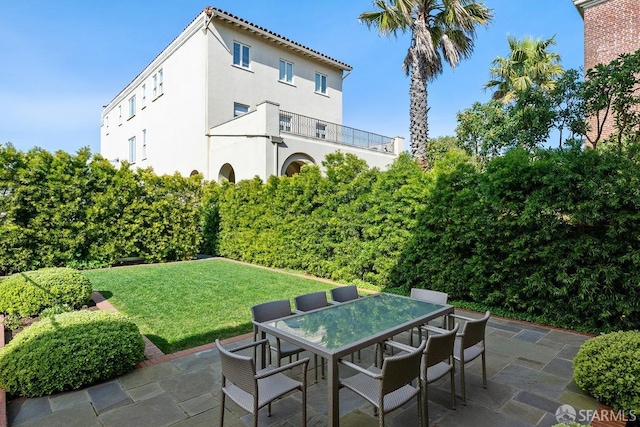 view of patio with outdoor dining area and a balcony