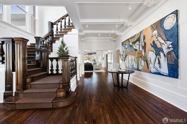 entrance foyer featuring baseboards, wood finished floors, beam ceiling, and stairs