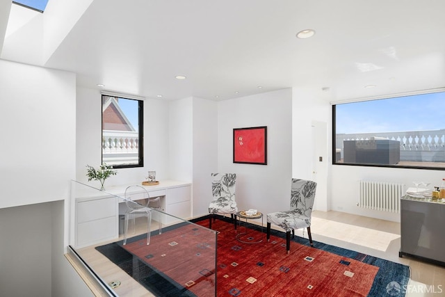 living area with recessed lighting, radiator heating unit, and wood finished floors