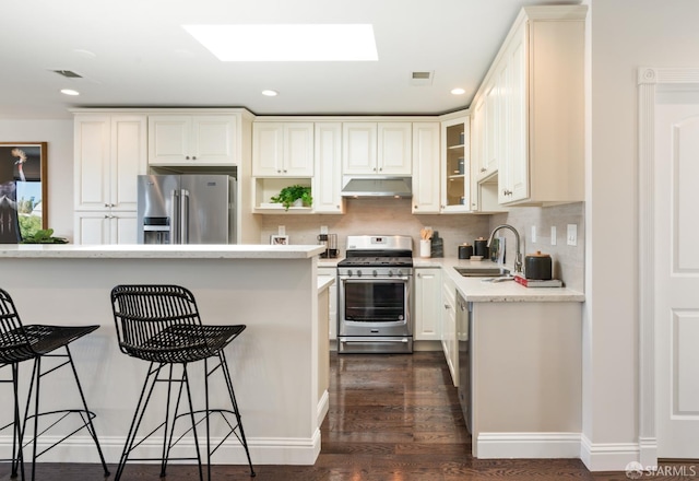 104 Bache St Unit A, San Francisco, CA 94110 - kitchen featuring appliances with stainless steel finishes, under cabinet range hood, a sink, a breakfast bar, and recessed lighting