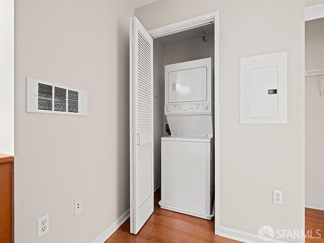 1701 Jackson St Unit 105, San Francisco, CA 94109 - laundry room featuring electric panel, stacked washer / dryer, laundry area, visible vents, and wood finished floors