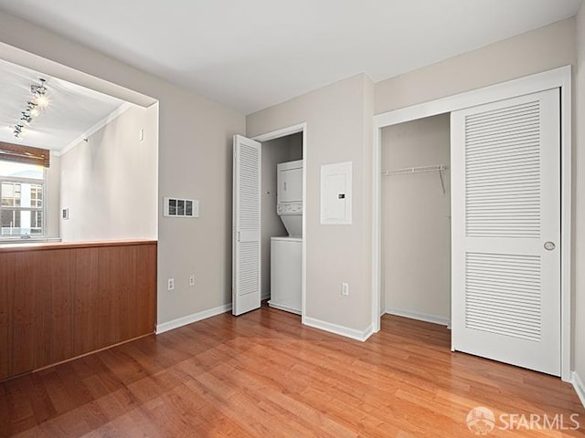 1701 Jackson St Unit 105, San Francisco, CA 94109 - unfurnished bedroom featuring visible vents, baseboards, electric panel, stacked washer / dryer, and light wood finished floors