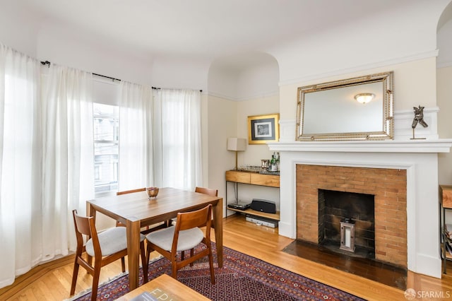 dining area with wood-type flooring and a fireplace