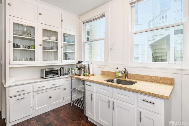 kitchen featuring white cabinets, dark hardwood / wood-style floors, sink, and a healthy amount of sunlight