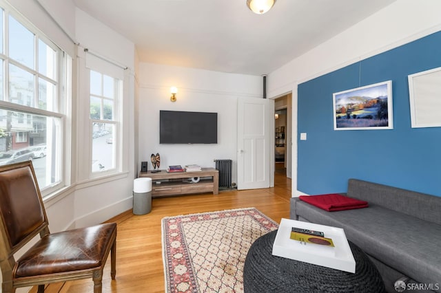 living room featuring hardwood / wood-style floors, radiator heating unit, and a wealth of natural light