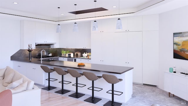 77 Crescent Ave, Sausalito, CA 94965 - kitchen with dark countertops, a peninsula, a raised ceiling, a kitchen breakfast bar, and backsplash