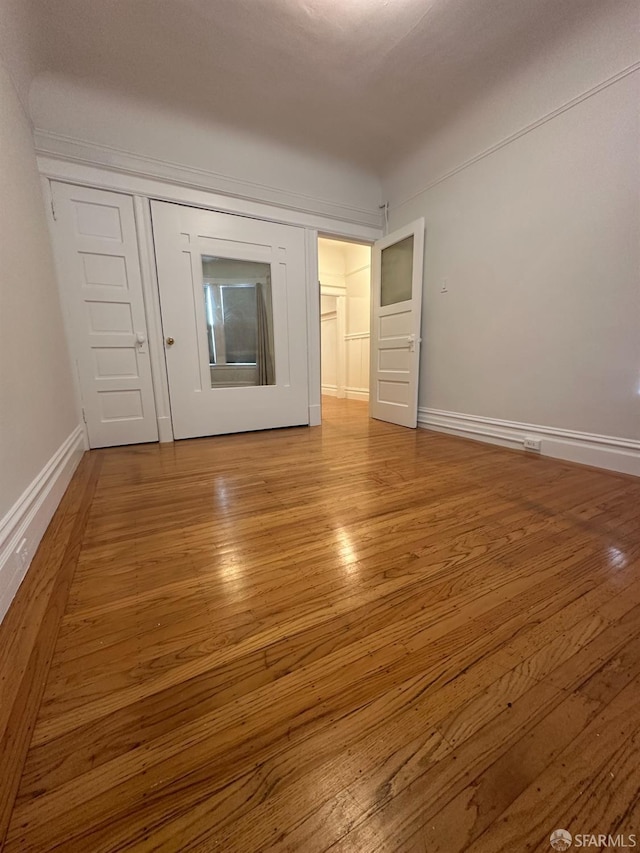 empty room with baseboards and wood finished floors