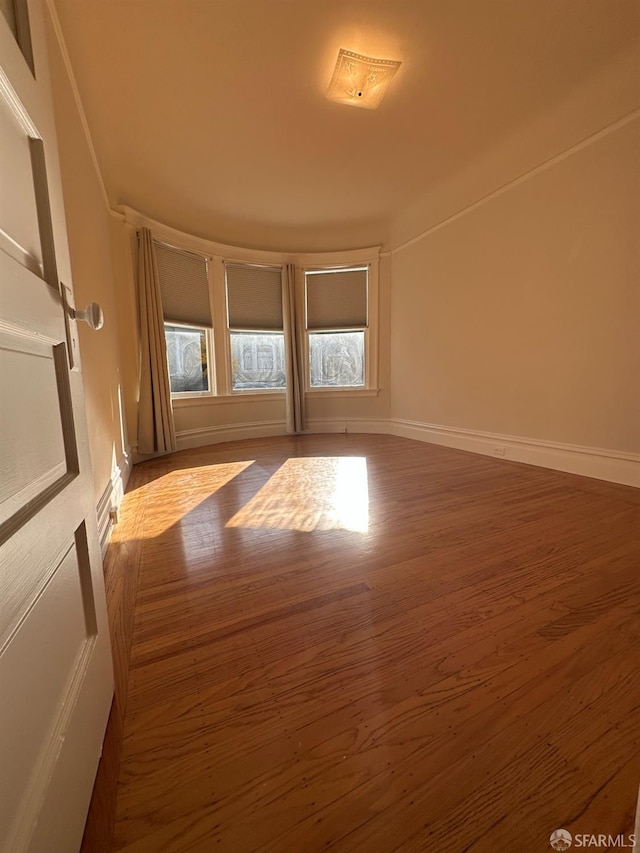 empty room featuring baseboards and wood finished floors