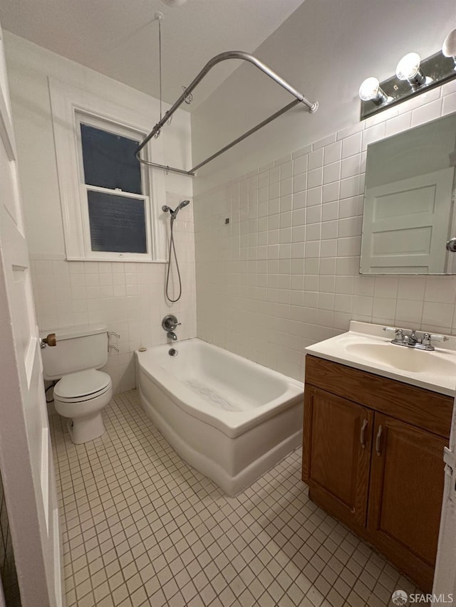 full bathroom featuring toilet, tile patterned flooring, vanity, and tile walls