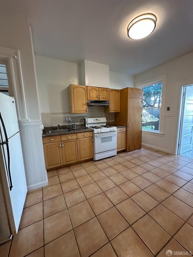 kitchen with white appliances, light tile patterned floors, under cabinet range hood, and decorative backsplash