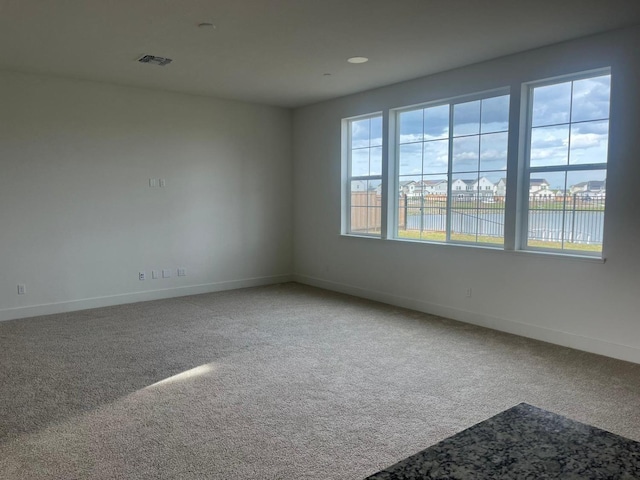 carpeted empty room with a water view