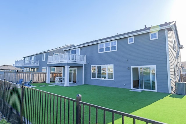 rear view of house with a lawn, a deck, central AC unit, a fenced backyard, and a patio