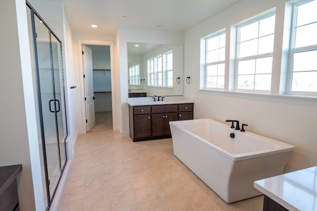 bathroom featuring vanity, recessed lighting, a spacious closet, a soaking tub, and a shower stall