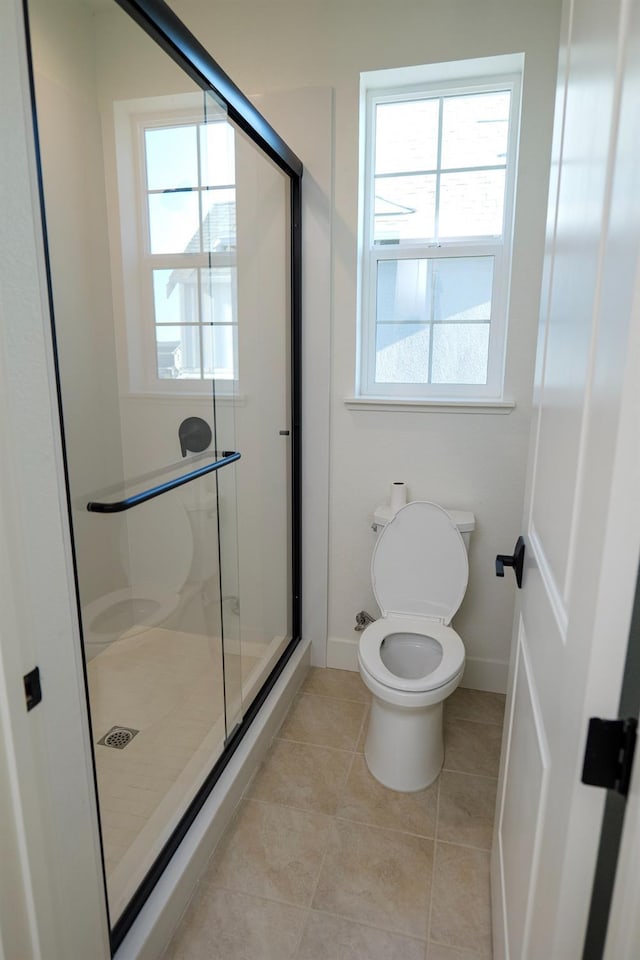 full bath with toilet, baseboards, a shower stall, and tile patterned floors