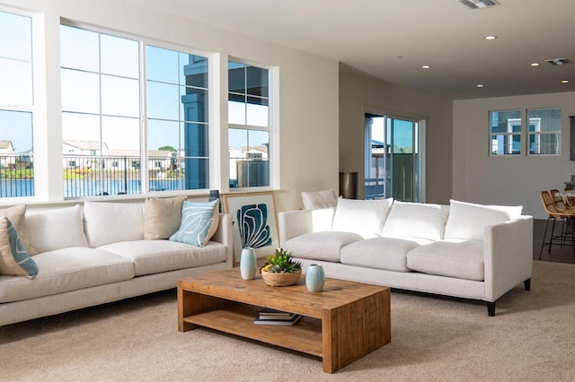 living area with carpet floors, recessed lighting, and visible vents