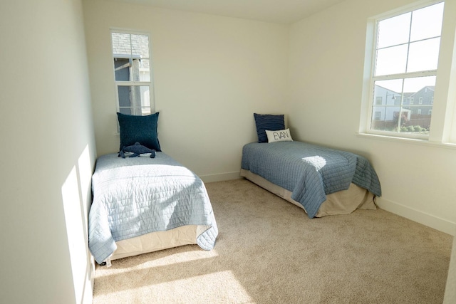 bedroom with baseboards, multiple windows, and carpet