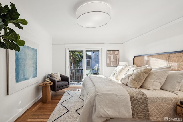 bedroom featuring access to exterior, ornamental molding, and hardwood / wood-style flooring