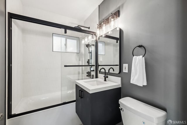 full bathroom with toilet, vanity, and bath / shower combo with glass door