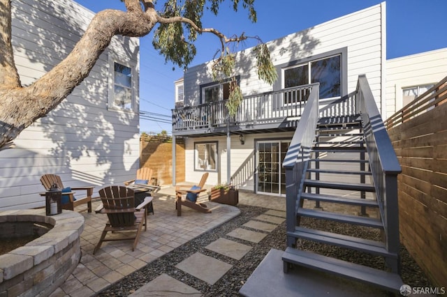 back of property with a patio area, a deck, and a fire pit