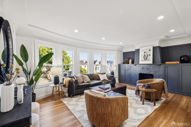 living room with light wood-type flooring and crown molding