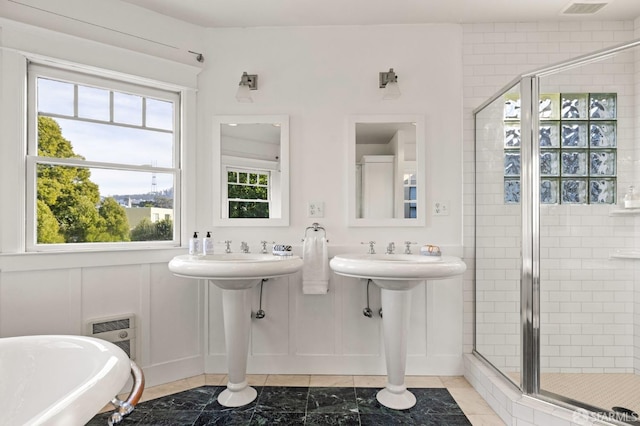 full bathroom featuring a freestanding bath, a shower stall, visible vents, and a decorative wall