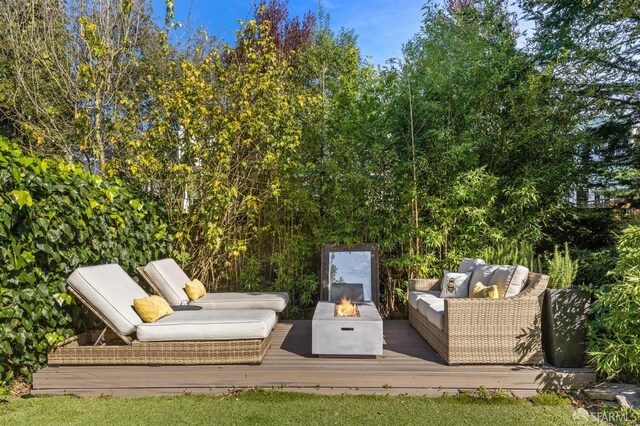 view of patio with a deck and an outdoor living space with a fire pit