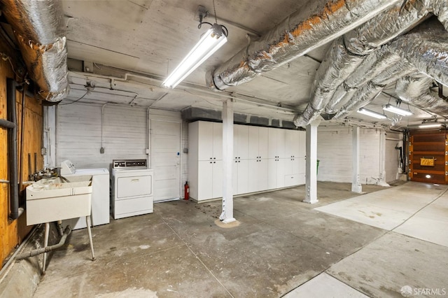 garage featuring separate washer and dryer and a sink