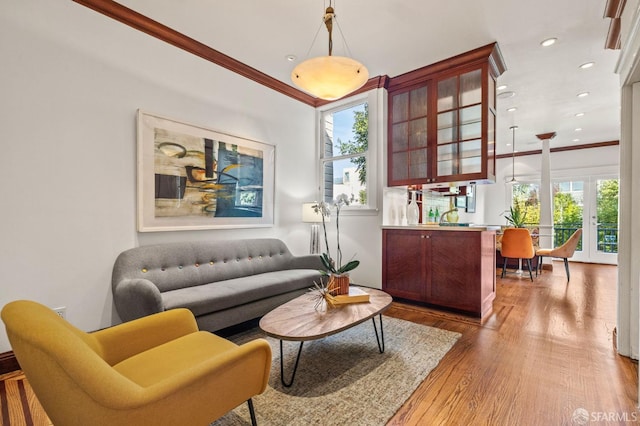 living area featuring ornamental molding, wood finished floors, and recessed lighting