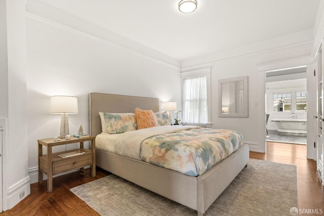 bedroom featuring wood finished floors and baseboards