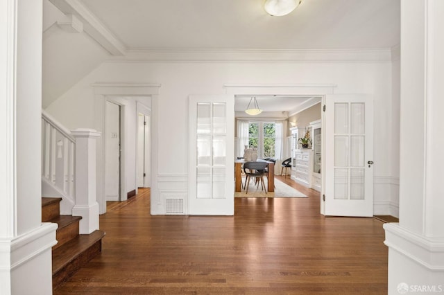 interior space featuring ornamental molding, visible vents, stairway, and wood finished floors