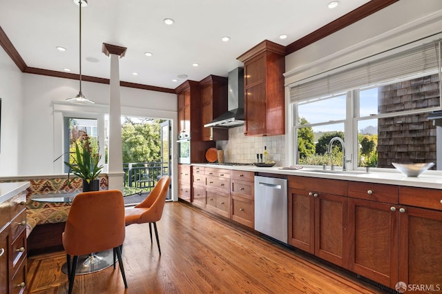 kitchen featuring a sink, a healthy amount of sunlight, wall chimney exhaust hood, and dishwasher