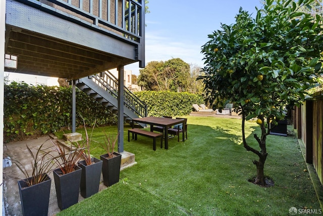 view of yard with fence and stairs