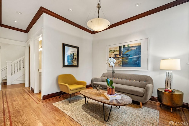 living room featuring ornamental molding, light wood finished floors, stairway, and baseboards