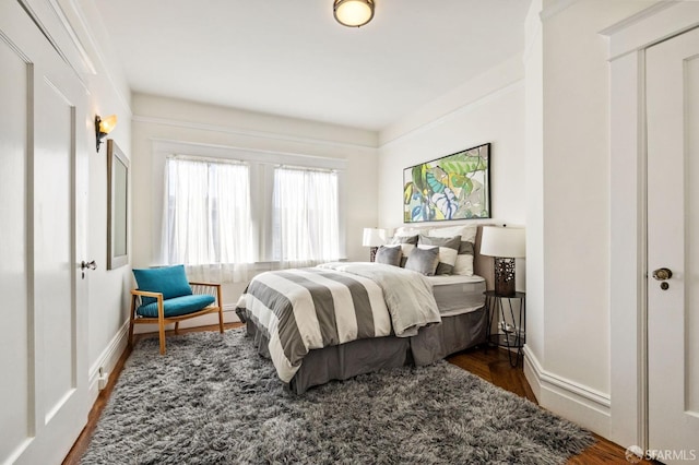 bedroom featuring baseboards and wood finished floors