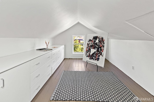 additional living space featuring lofted ceiling and dark hardwood / wood-style floors