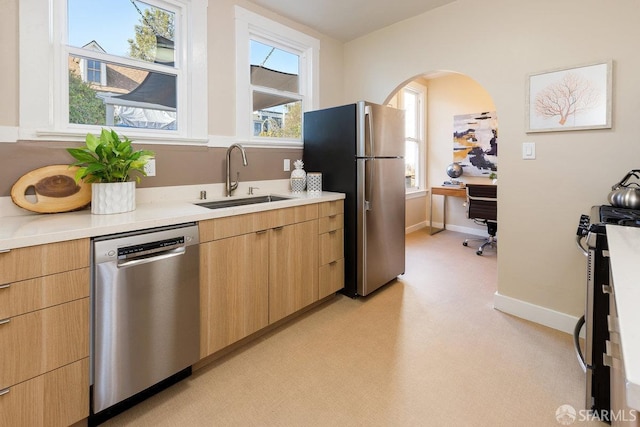 kitchen with stainless steel appliances, sink, and light brown cabinets