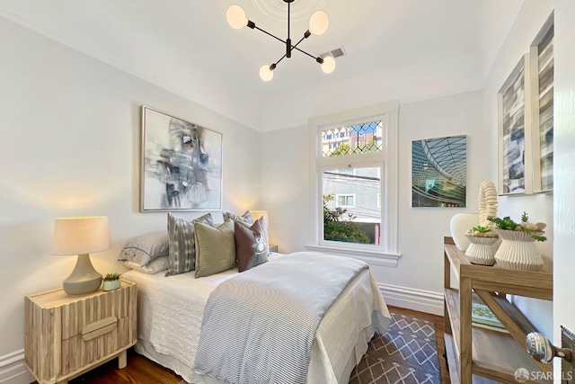 bedroom featuring dark hardwood / wood-style floors and a notable chandelier