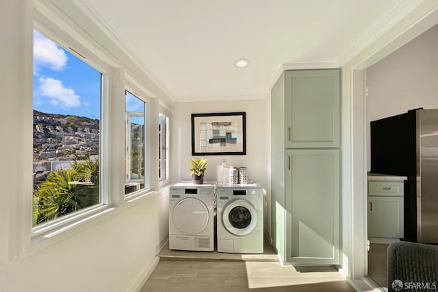 washroom with separate washer and dryer, light hardwood / wood-style flooring, and ornamental molding