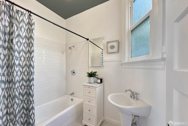 bathroom featuring shower / tub combo with curtain and sink