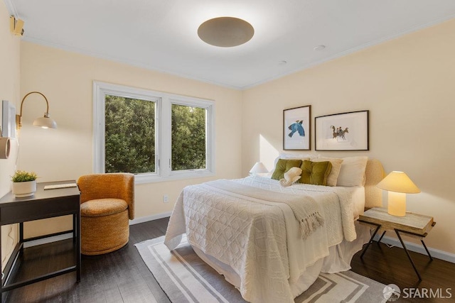 bedroom with baseboards, wood finished floors, and ornamental molding